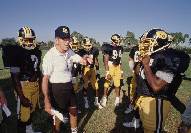 Long Beach State head coach George Allen gives coaching instructions to his players before their opening game against Utah State on Sept. 1, 1990, in Long Beach. (Photo by Ken Levine/Allsport/Getty Images)