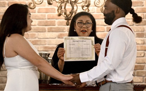 Deputy commissioner of marriage Hilda Barraza holds up the marriage license of Andrea and Colvin Martin as she announces them husband and wife following their marriage at the Thee Olde Chapel in Riverside on Leap Day Thursday, Feb. 29, 2024. Ten couples took the 鈥渓eap鈥� of marriage on leap year day at the church. (Photo by Will Lester, Inland Valley Daily Bulletin/SCNG)
