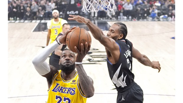 Lakers forward LeBron James, left, shoots as Clippers forward Kawhi Leonard defends during the first half on Wednesday night at Crypto.com Arena. James scored 19 of his 34 points during an electric fourth-quarter display as the Lakers erased a 21-point deficit to win, 116-112. (AP Photo/Mark J. Terrill)

