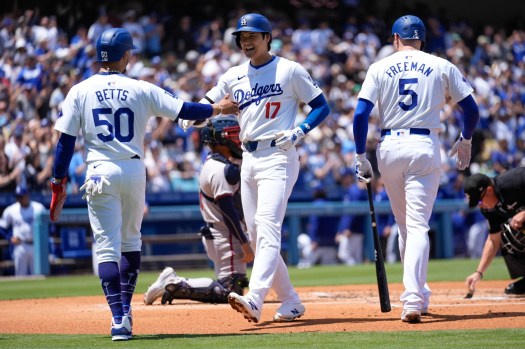 Los Angeles Dodgers designated hitter Shohei Ohtani (17) celebrates with Mookie Betts (50) and Freddie Freeman (5) after hitting a home run during the first inning of a baseball game against the Atlanta Braves in Los Angeles, Sunday, May 5, 2024. Betts also scored. (AP Photo/Ashley Landis)
