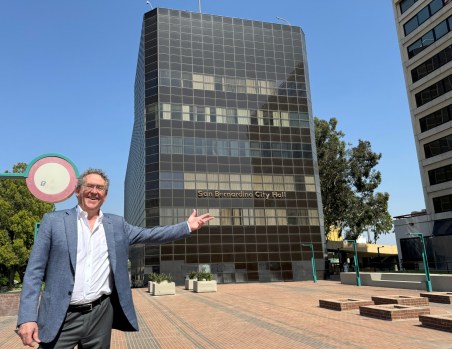 Rafael Pelli gestures toward San Bernardino City Hall, a 1972 building designed by his father, César Pelli, and widely considered an architectural masterpiece. The building was vacated in 2017 due to seismic risk. The younger Pelli visited Wednesday as part of an effort to renovate and reopen it. (Photo by David Allen, Inland Valley Daily Bulletin/SCNG)
