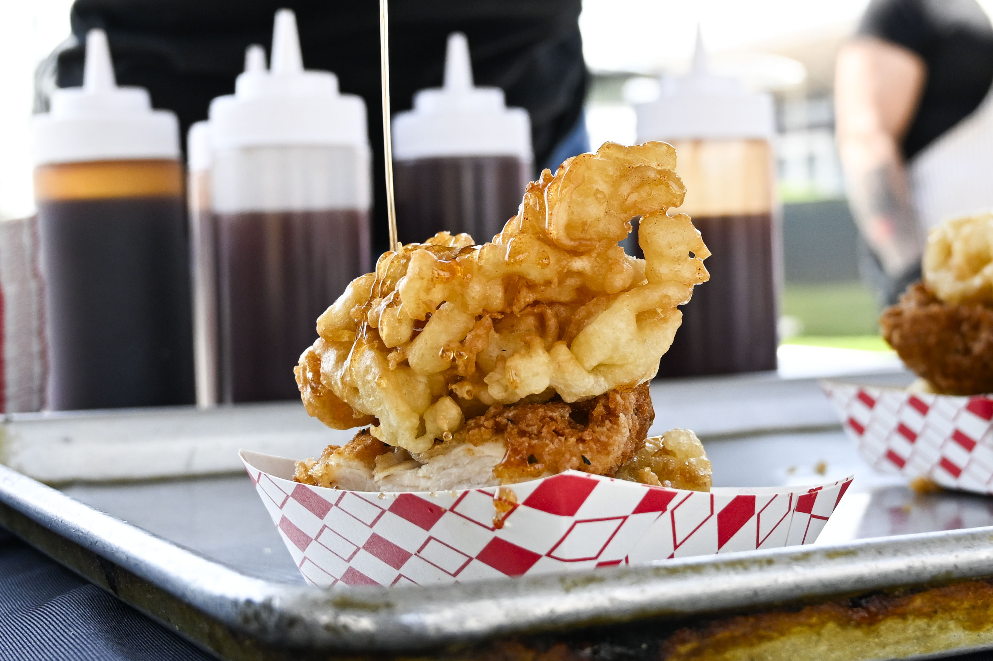 Hot honey drips onto a fried chicken and funnel cake...
